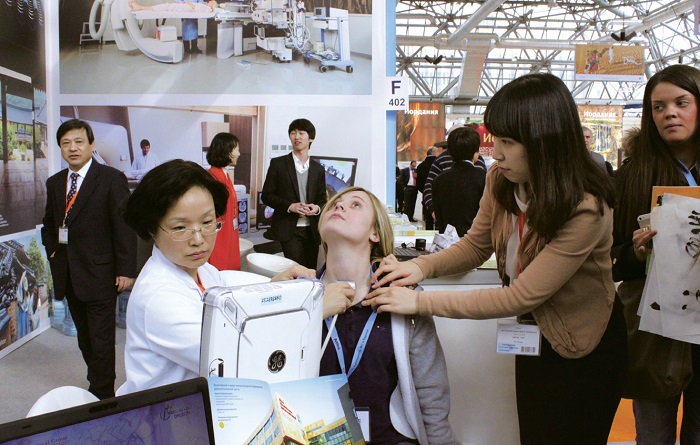 A Korean medical institution conducts a thyroid examination on a visitor at the 2013 Moscow International Travel & Tourism Exhibition. © Yonhap News 