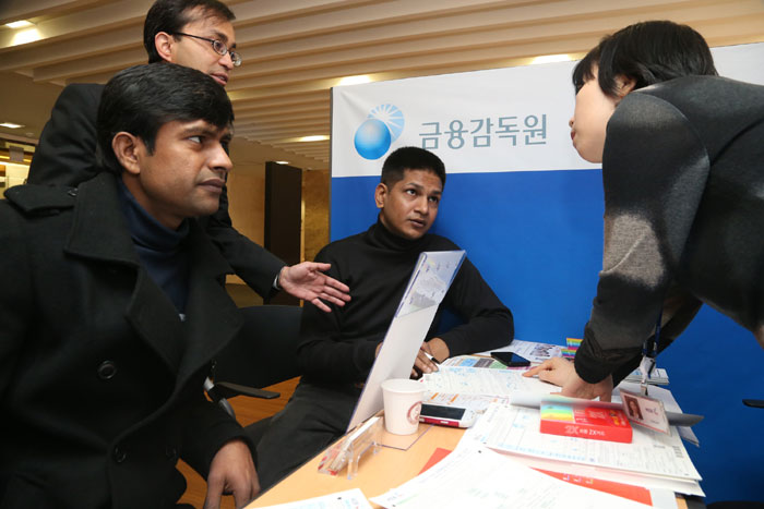 Foreign workers receive a financial consultation with a Korean officer. (photo: Yonhap News)