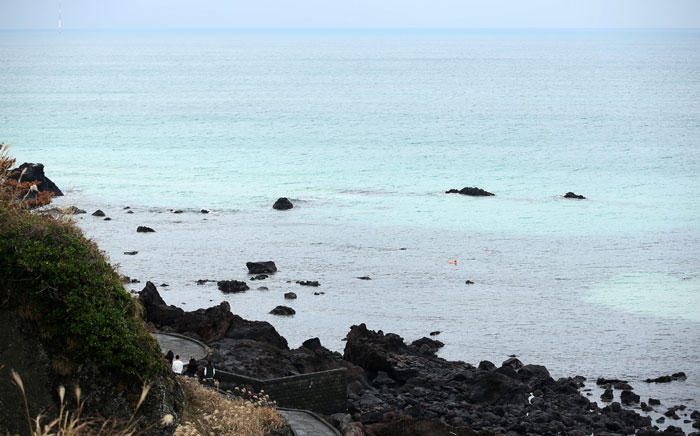 A beach with black rocks can be seen at the Aewolhae, located in Aewol-eup. The black rocks are in clear contrast to the seashore and to the sea, making the water appear even bluer.