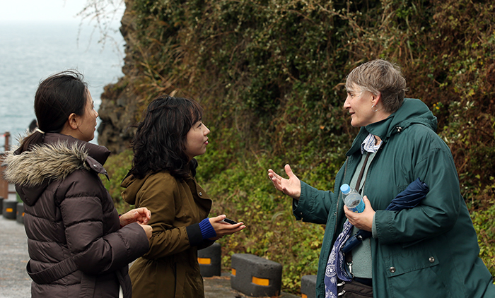 Martha McIntyre (right) explains that she is visiting Jejudo Island for the second time. She said that the colors of blue and green that she can see throughout the landscape are the best part of the trip.