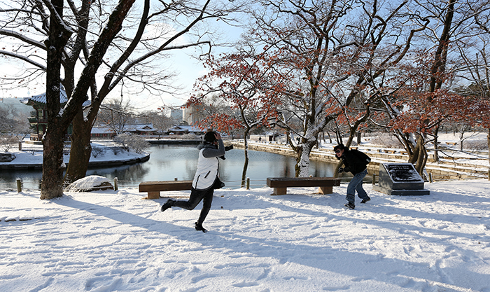 Chinese visitors engage in a snowball fight early in the morning at snow-covered Gyeongbokgung Palace on December 11. (Photo: Jeon Han)